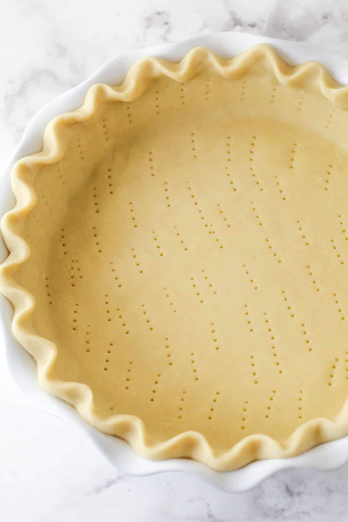 docked pie crust in white pie plate