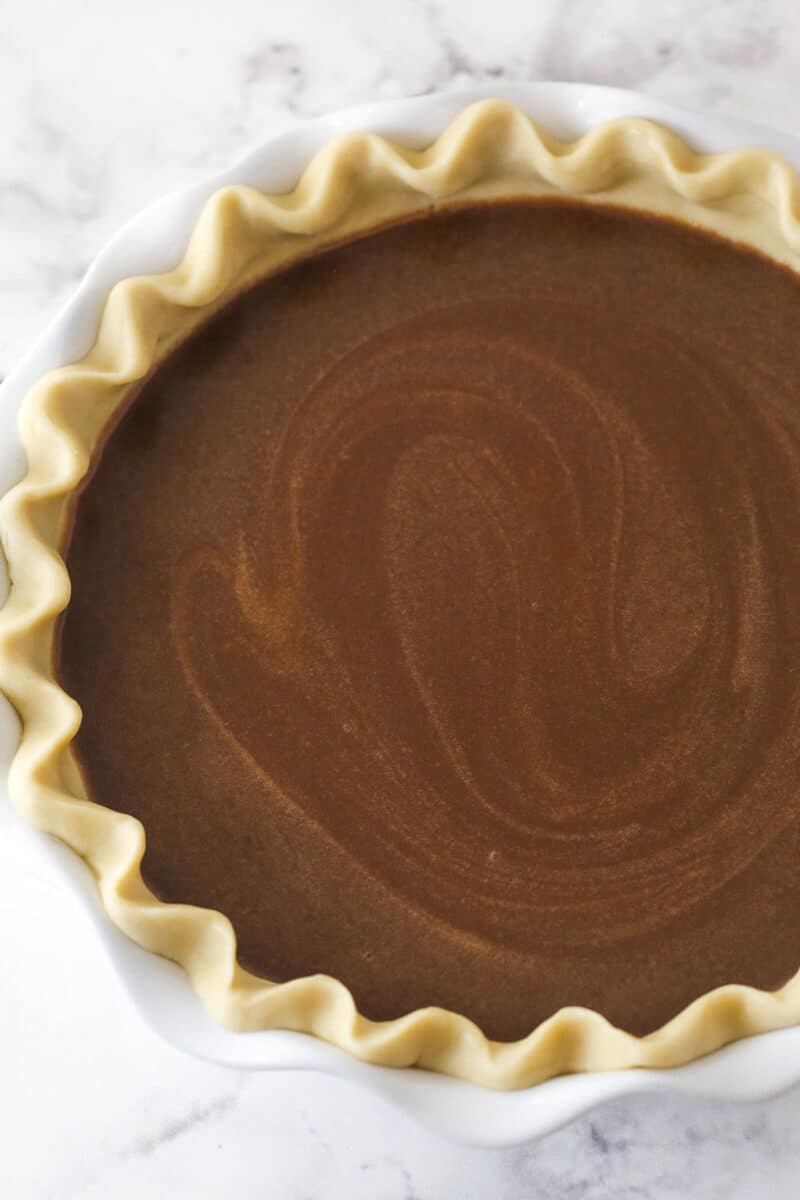 filled pie crust in white pie plate