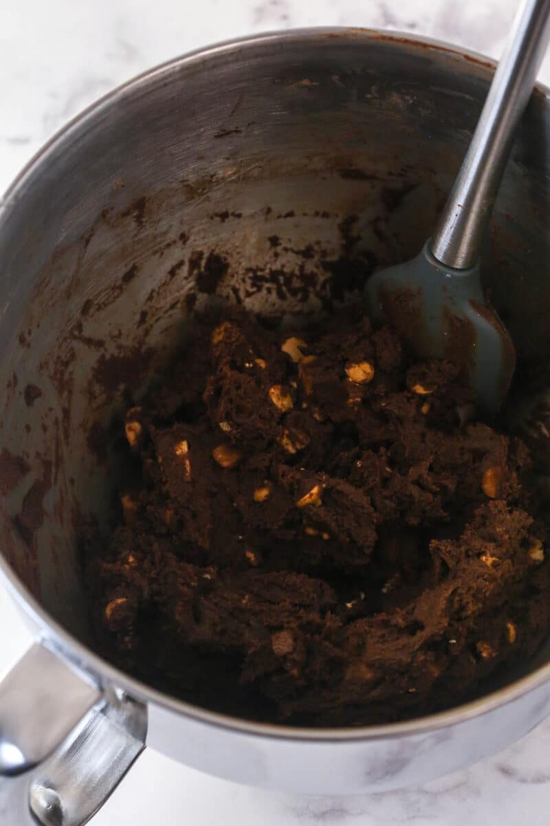 Stirring chocolate chips and peanut butter chips into cookie dough