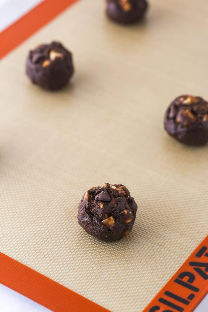 Balls of Snickers cookie dough on a baking sheet