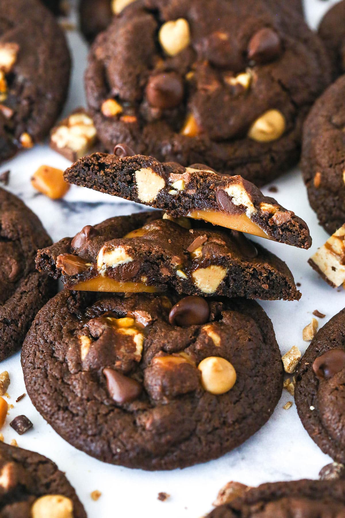 A Snickers cookie broken in half on top of another cookie