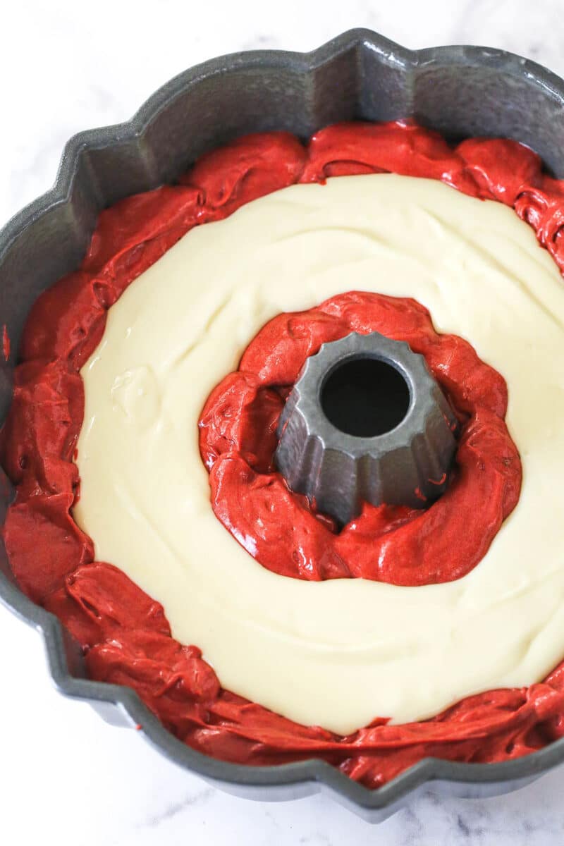 Cheesecake filling added to a bundt pan with red velvet cake batter