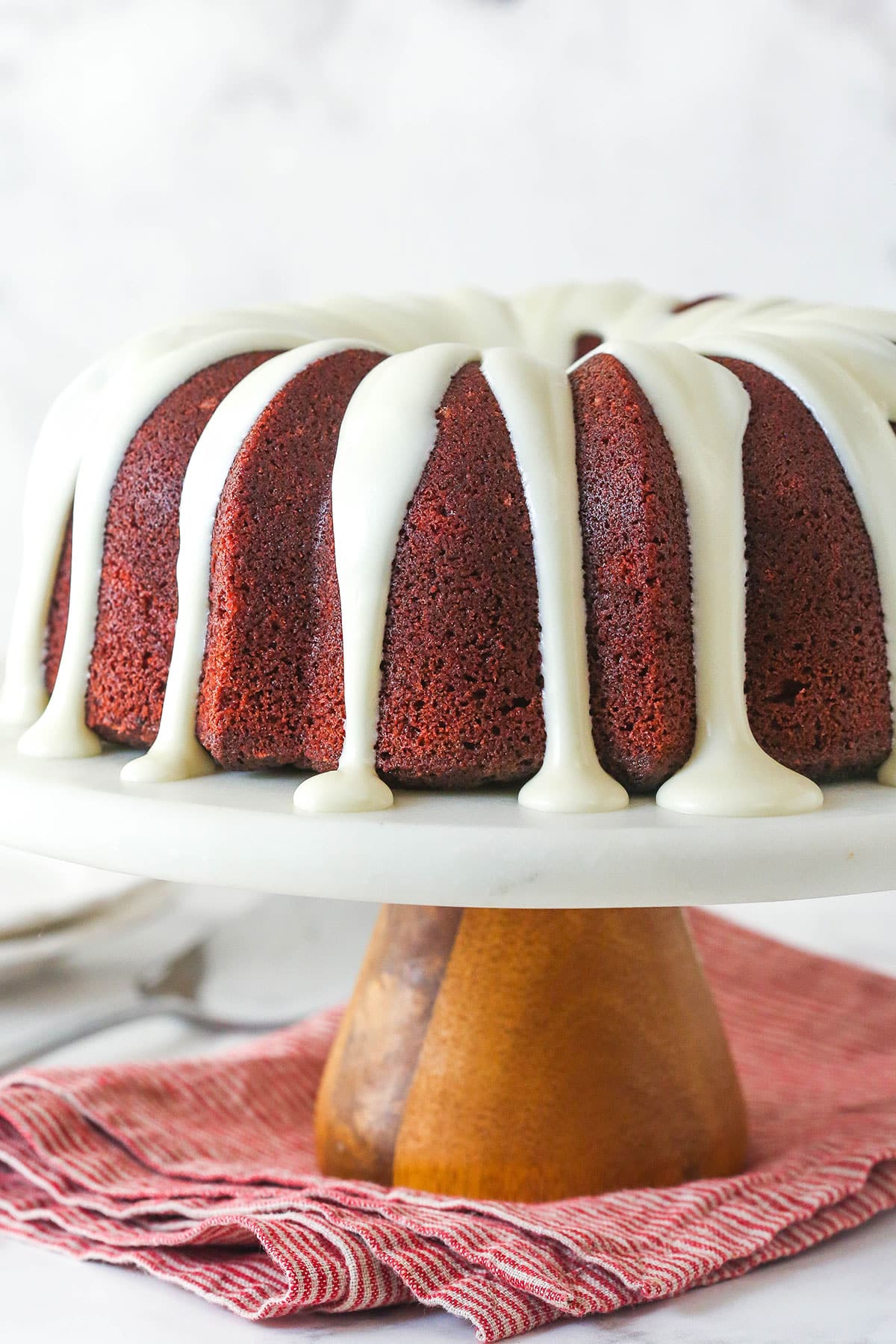 A red velvet cheesecake swirl bundt cake on a cake stand