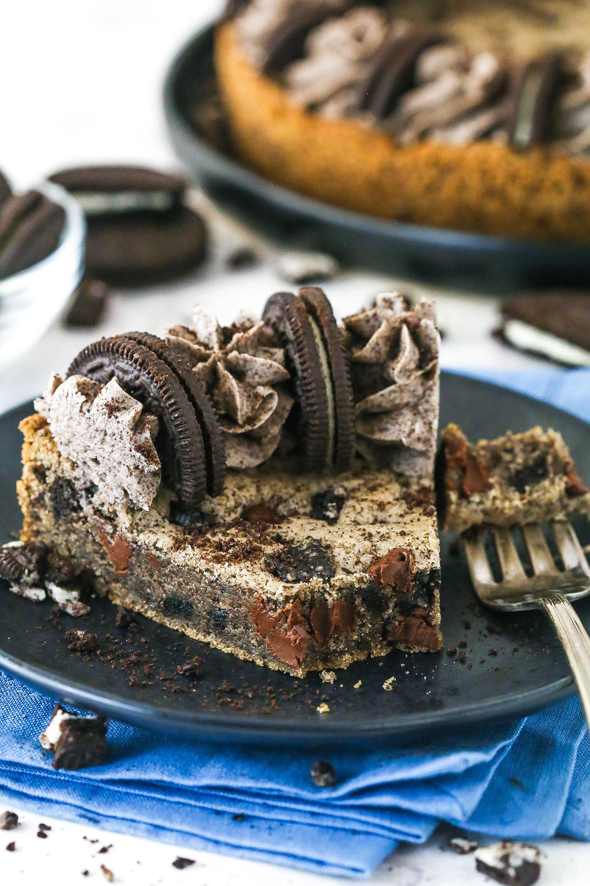 A slice of Oreo cookie cake with a piece on a fork