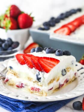 slice of berry icebox cake on white plate with blue napkin underneath