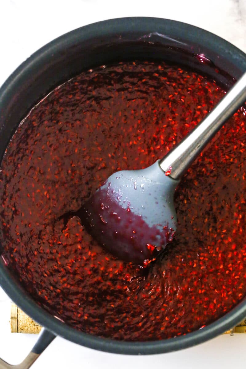 Stirring raspberry filling in a pan