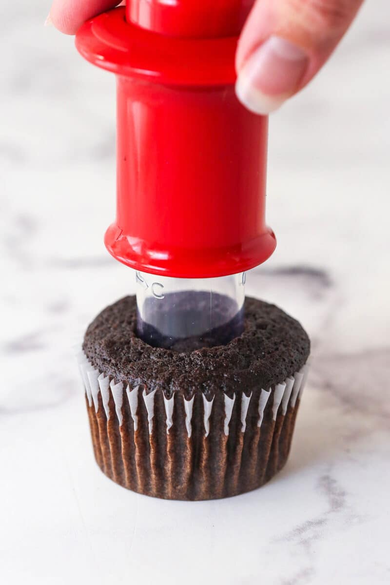 Using a cupcake corer to remove the center of a chocolate cupcake