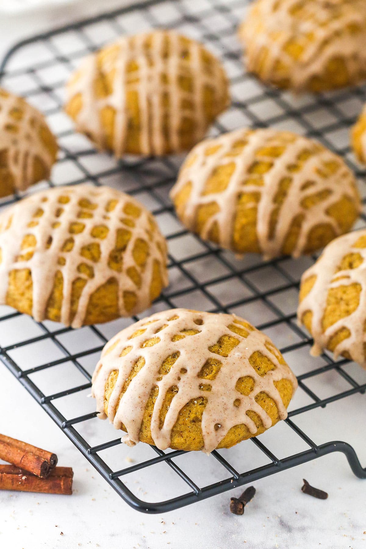 Overhead view of pumpkin cookies with cinnamon glaze on a cooling rack