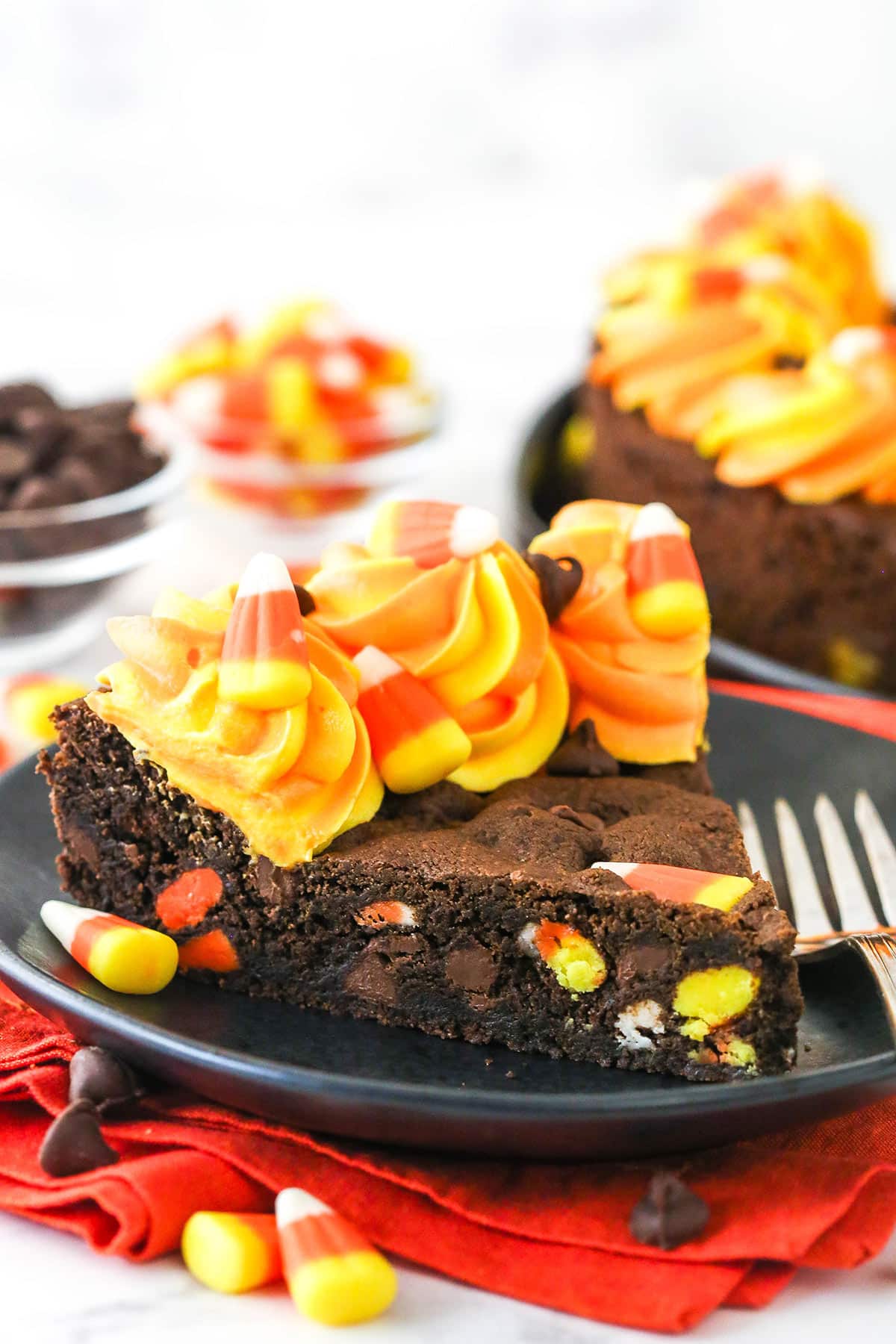 A slice of Candy Corn Chocolate Chip Cookie Cake on a small black plate.