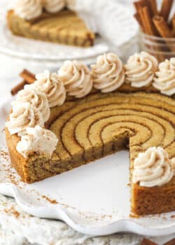 A cinnamon roll cookie cake with a slice missing