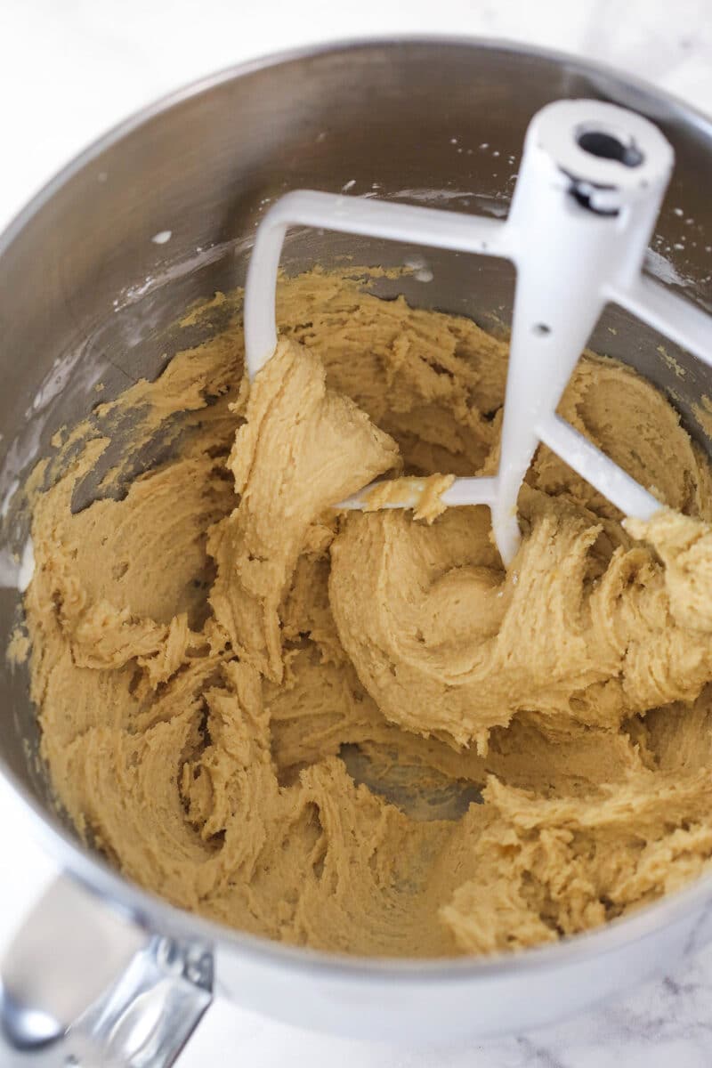 Caramel buttercream in a mixing bowl after adding some heavy cream