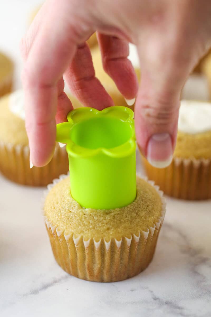 A hand using a cupcake corer