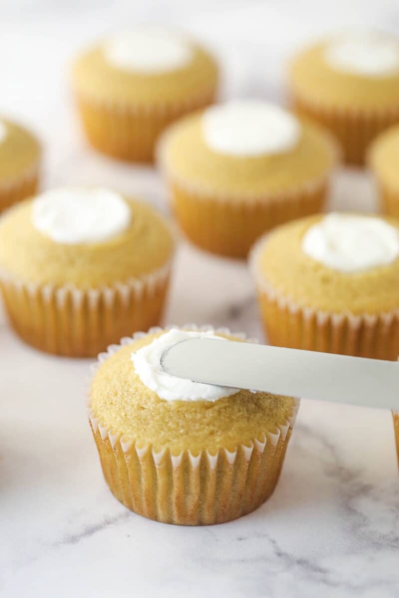 A knife smoothing the filling on brown sugar cookies