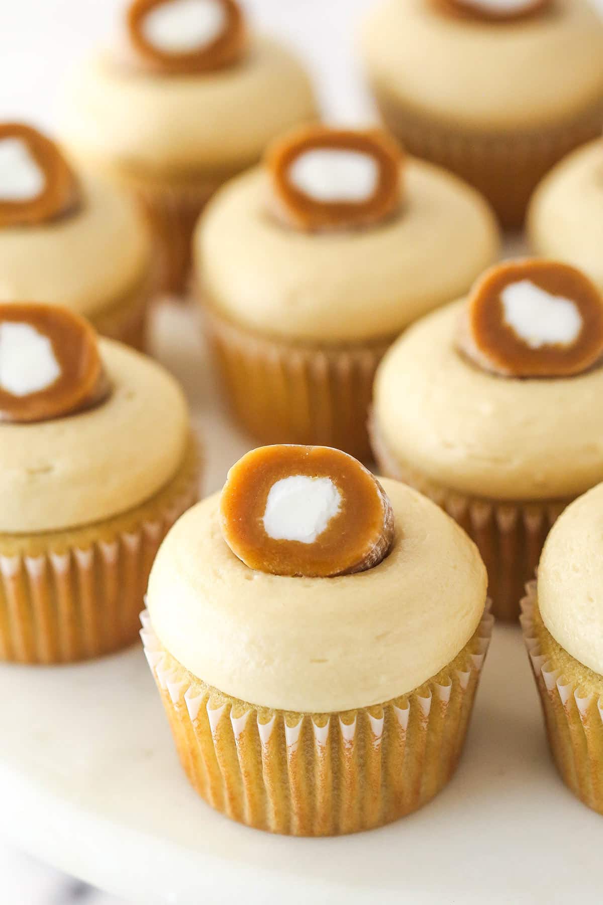 caramel cream cupcakes on a marble cake stand