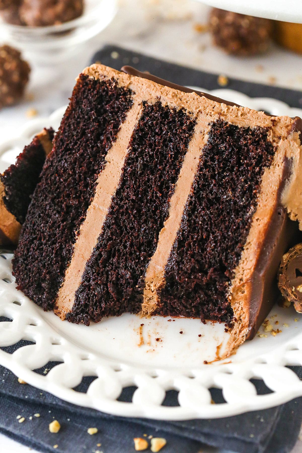 A slice of Nutella chocolate cake on a white plate with a bite taken out