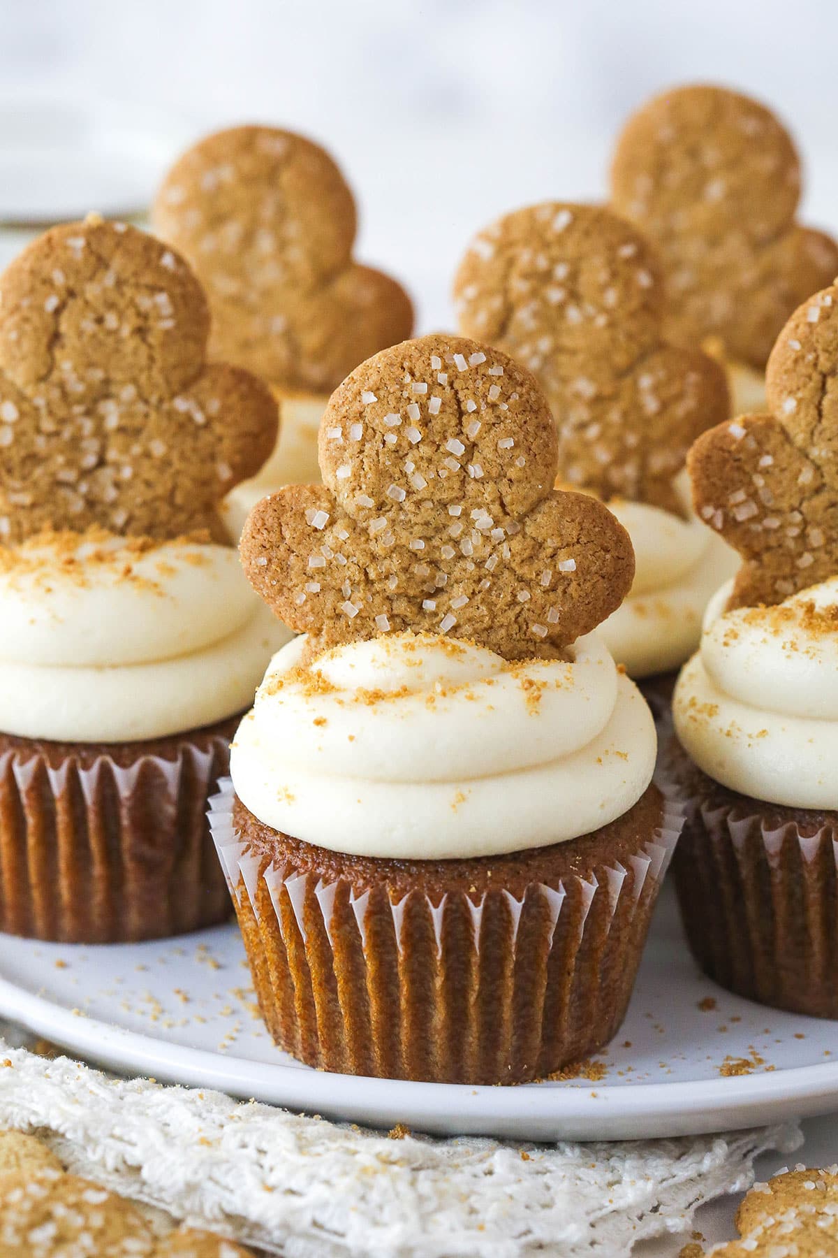 Frosted gingerbread cupcakes topped with a gingerbread cookie