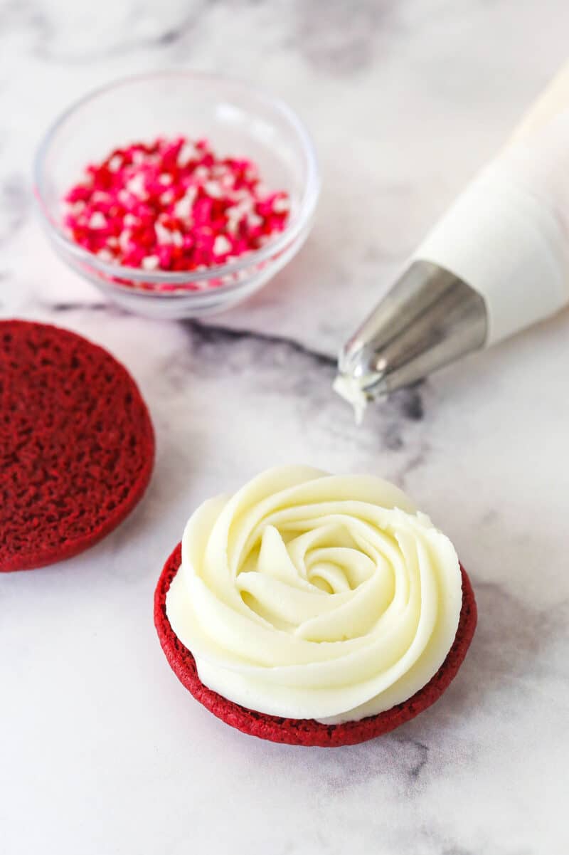 Cream cheese frosting piping on a red velvet cookie