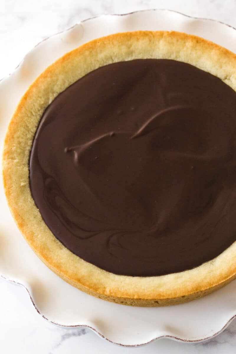 Chocolate ganache spread over sugar cookie cake