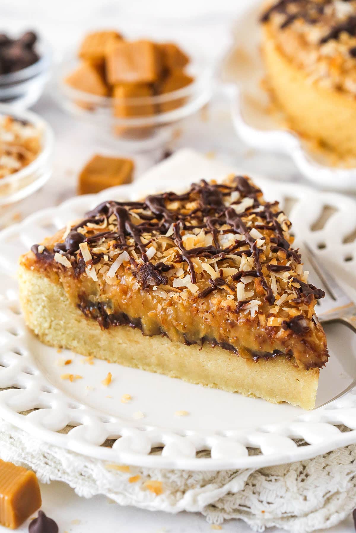 A slice of Samoa cookie cake on a white plate