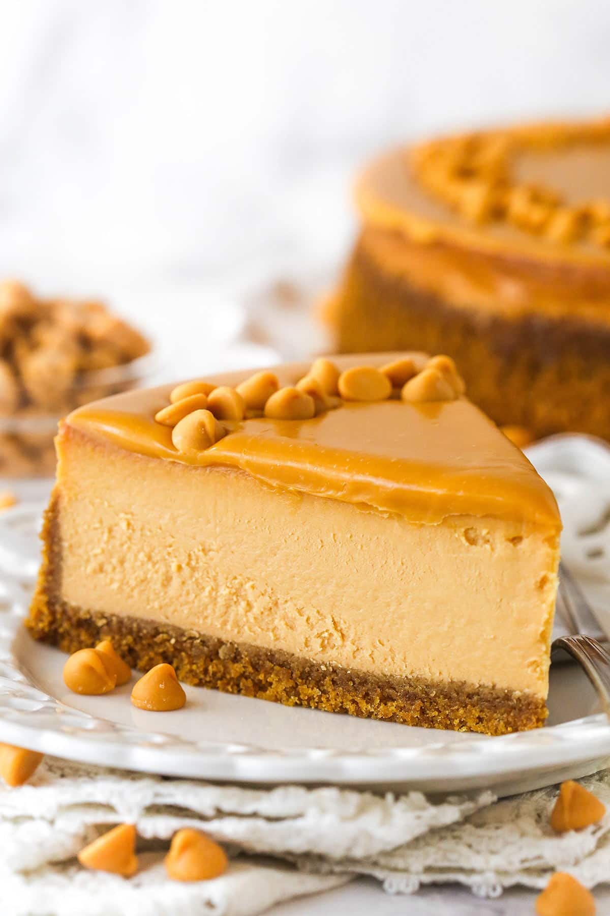 A slice of butterscotch cheesecake on a white plate