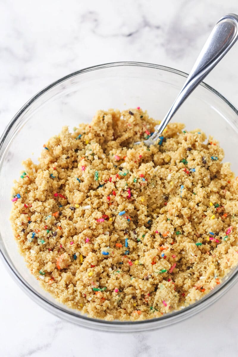 Golden Oreo crumbs, sprinkles, and melted butter in a bowl