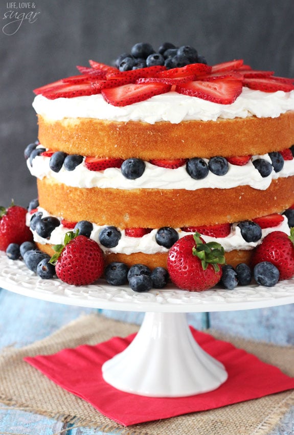 Fresh Berry Vanilla Layered Cake - layers of moist vanilla cake flavored with pureed strawberries and blueberries, layered with fresh berries and whipped cream! #pictureperfectplate