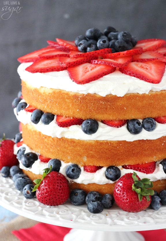 Fresh Berry Vanilla Layered Cake - layers of moist vanilla cake flavored with pureed strawberries and blueberries, layered with fresh berries and whipped cream! #pictureperfectplate