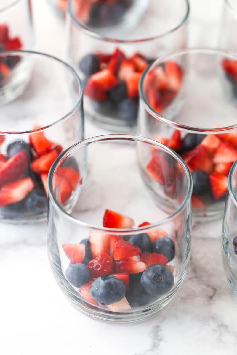 strawberries and blueberries divided between glass cups