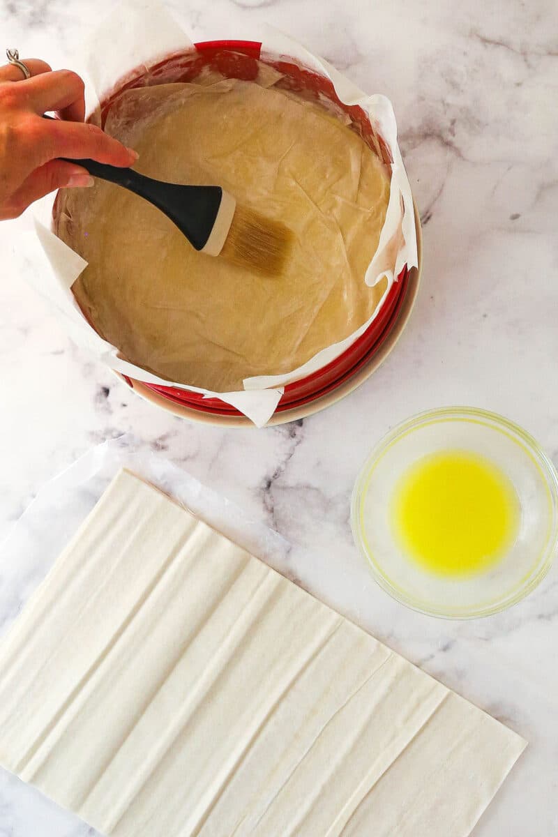 Buttering the phyllo dough in a springform pan