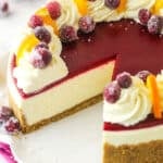 A cranberry orange cheesecake with a slice missing