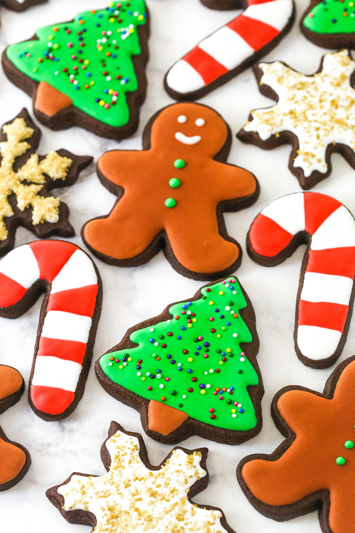 decorated Christmas cutout cookies on a marble countertop