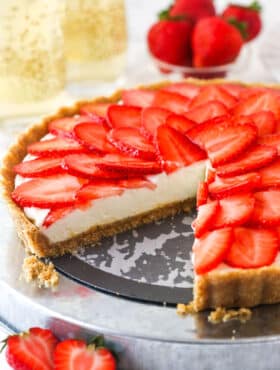 strawberry champagne tart on silver platter with slice cut out