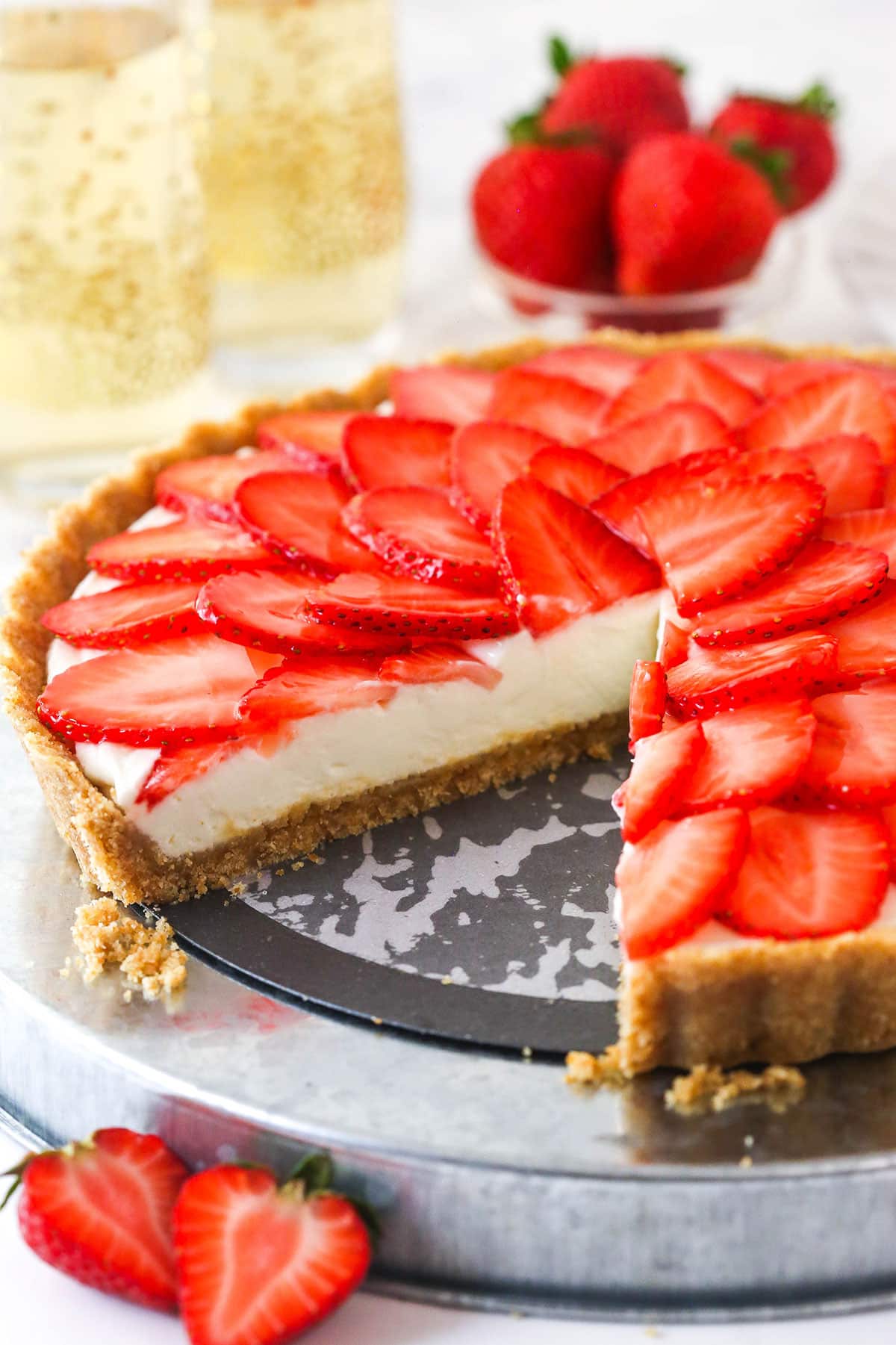 strawberry champagne tart on silver platter with slice cut out