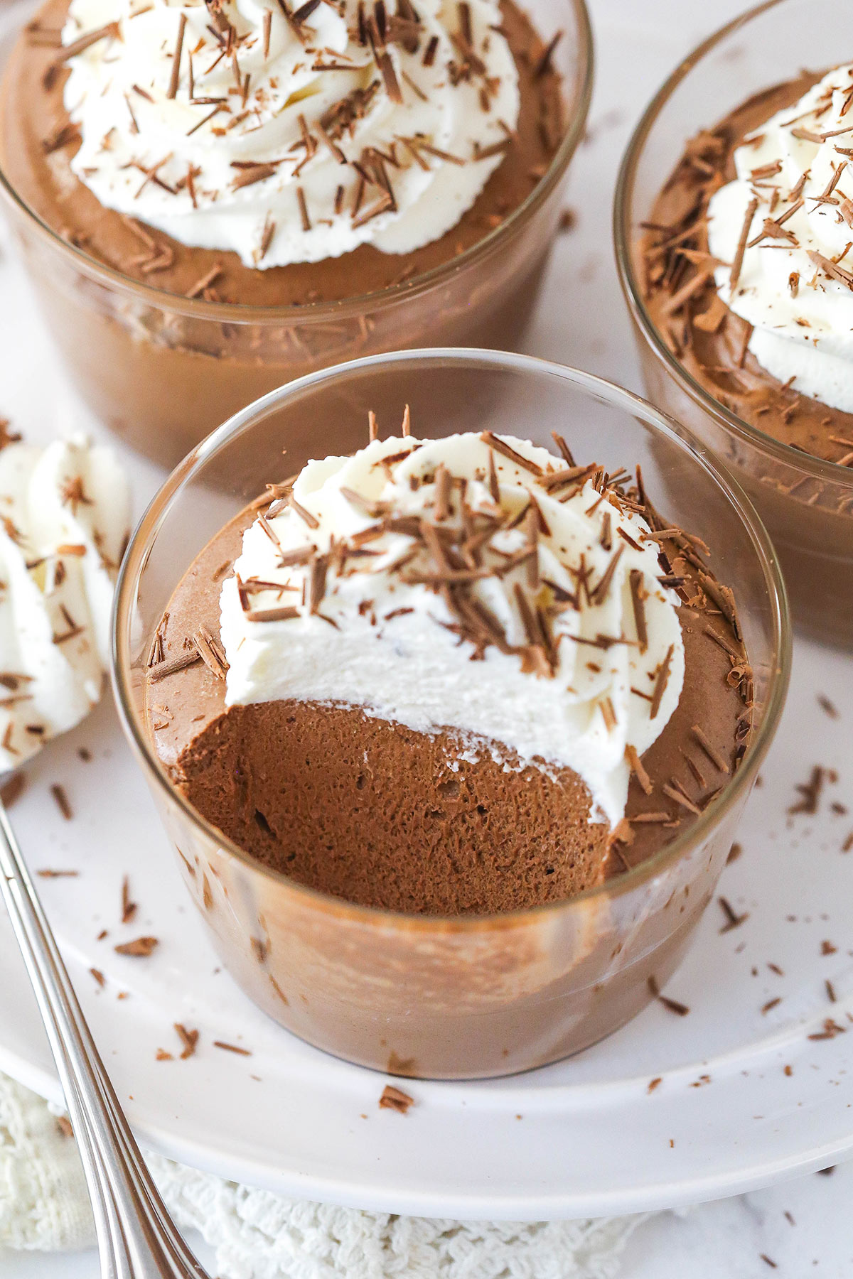 Overhead view of chocolate mousse cups with a few bites missing from one