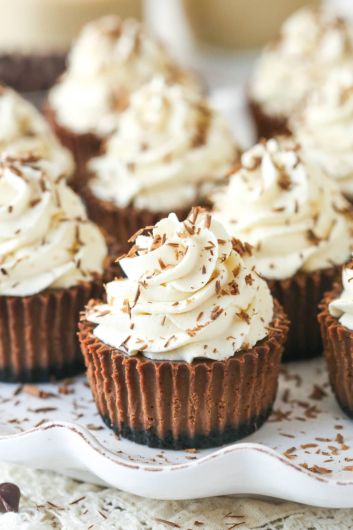 mini baileys chocolate cheesecakes on a white ruffle platter