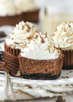 mini baileys chocolate cheesecake on a white plate with a bite taken out