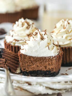 mini baileys chocolate cheesecake on a white plate with a bite taken out