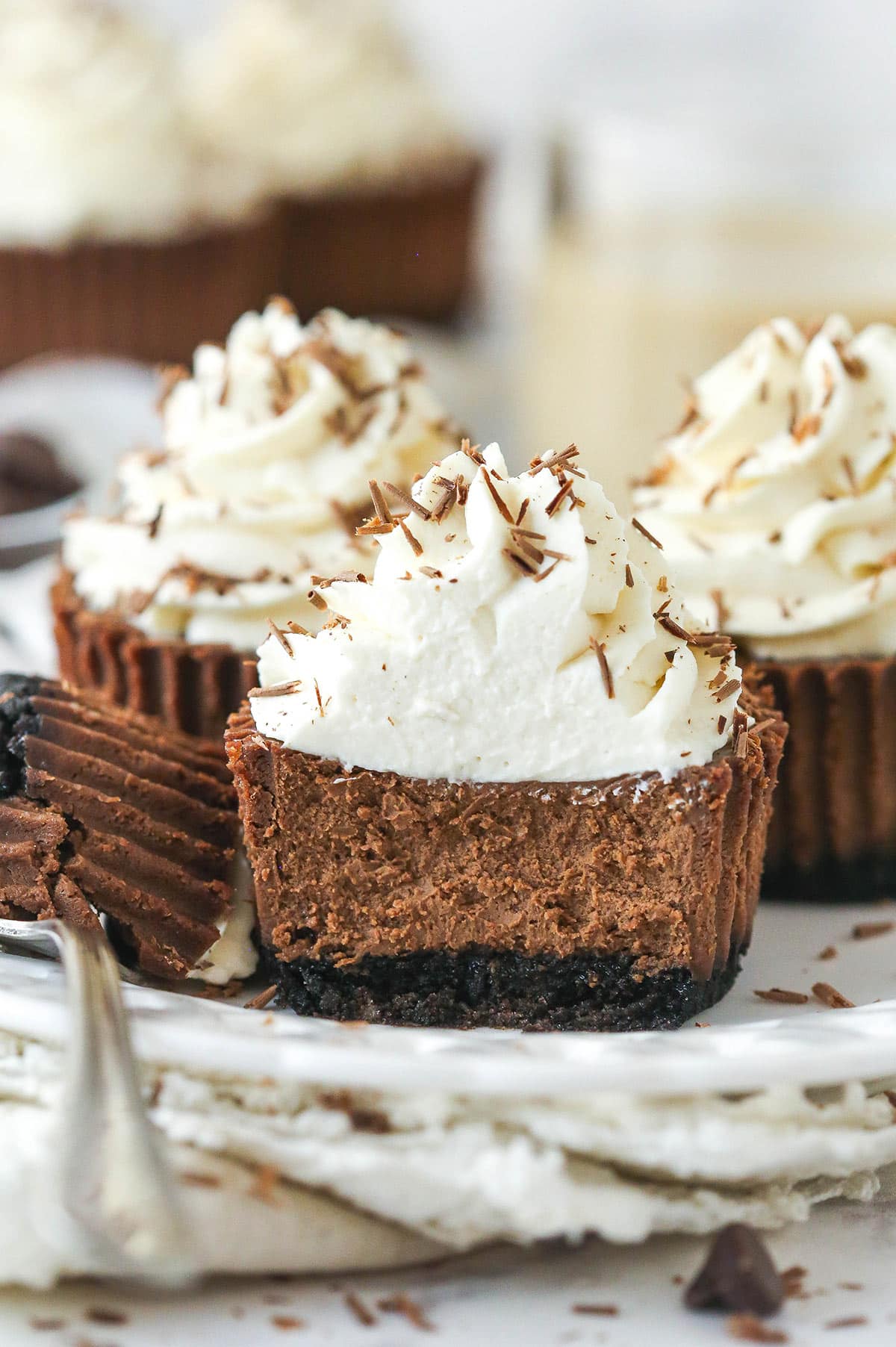 mini baileys chocolate cheesecake on a white plate with a bite taken out