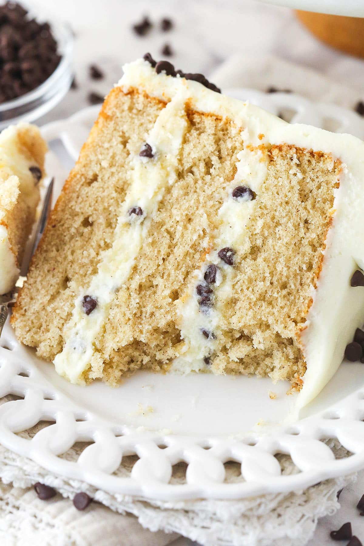 A slice of cannoli layer cake on a plate with a few bites missing