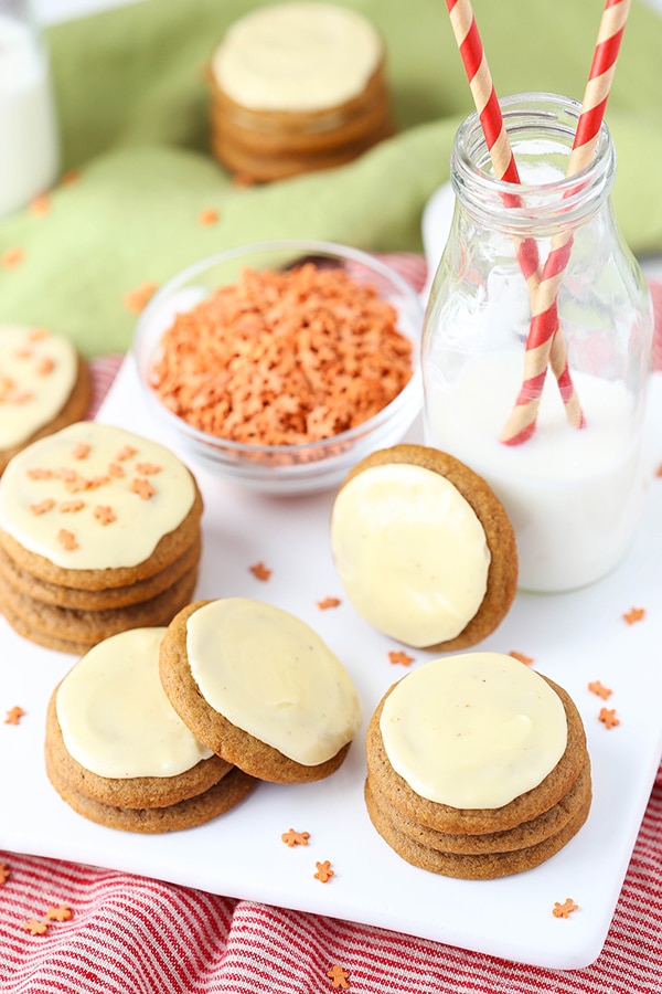 Overhead image of gingerbread cookies with eggnog icing on a plate with a jar of milk.