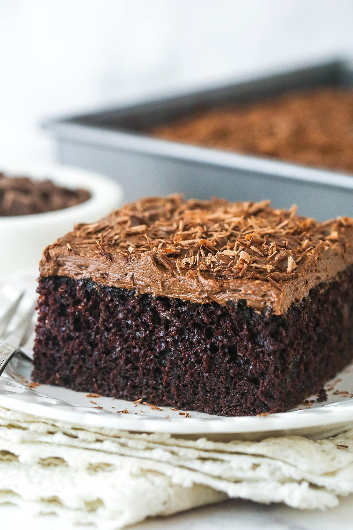 close up of a slice of chocolate sheet cake on white plate