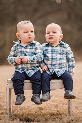 twins on a bench in a field