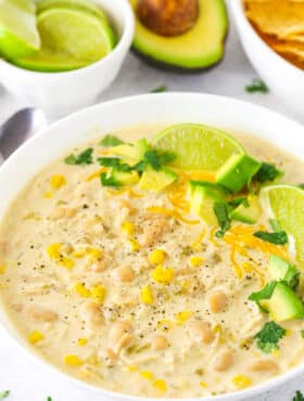 A Bowl of Instant Pot White Chicken Chili with Limes and Avocado