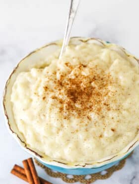 Warm Rice Pudding in a Teal Bowl with a Silver Spoon.