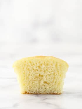 A moist vanilla cupcake cut in half to reveal its interior