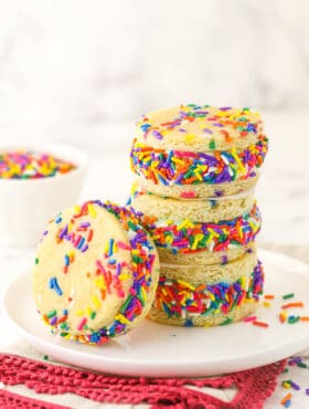 Three ice cream sandwiches piled on top of one another with a fourth one leaning against the stack