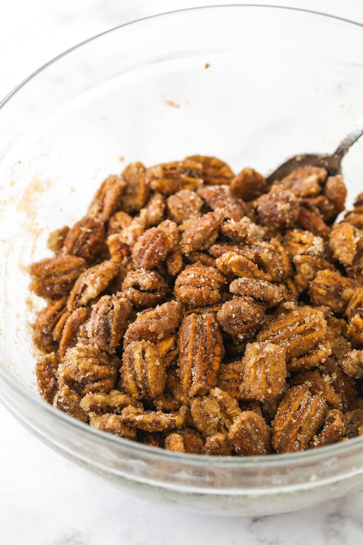 A bowl of pecans coated evenly in both the egg white and sugar mixtures