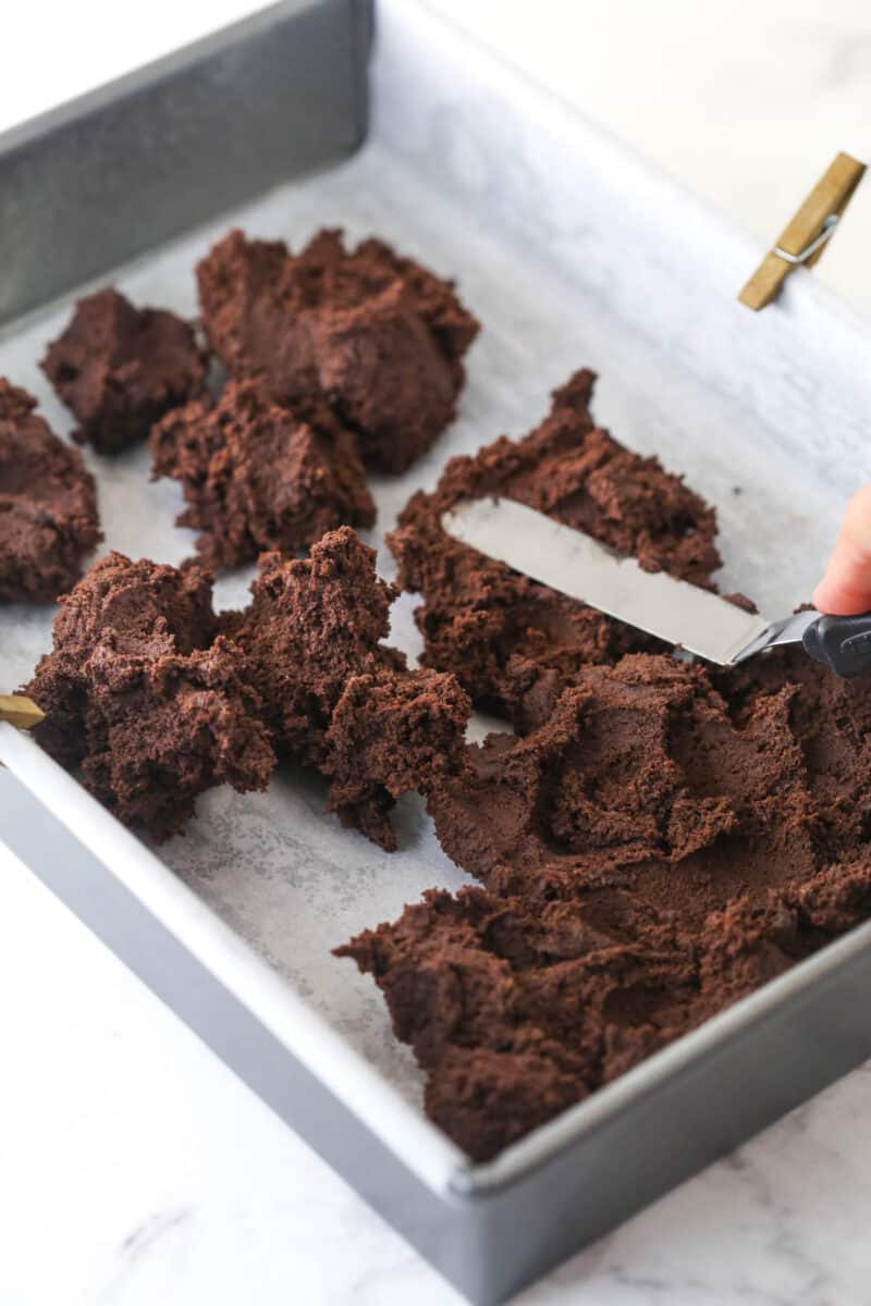 Putting spoonfuls of cookie batter into the prepared baking pan.