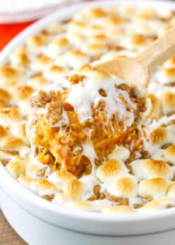 A scoop of Loaded Sweet Potatoes being taken with a wooden spoon