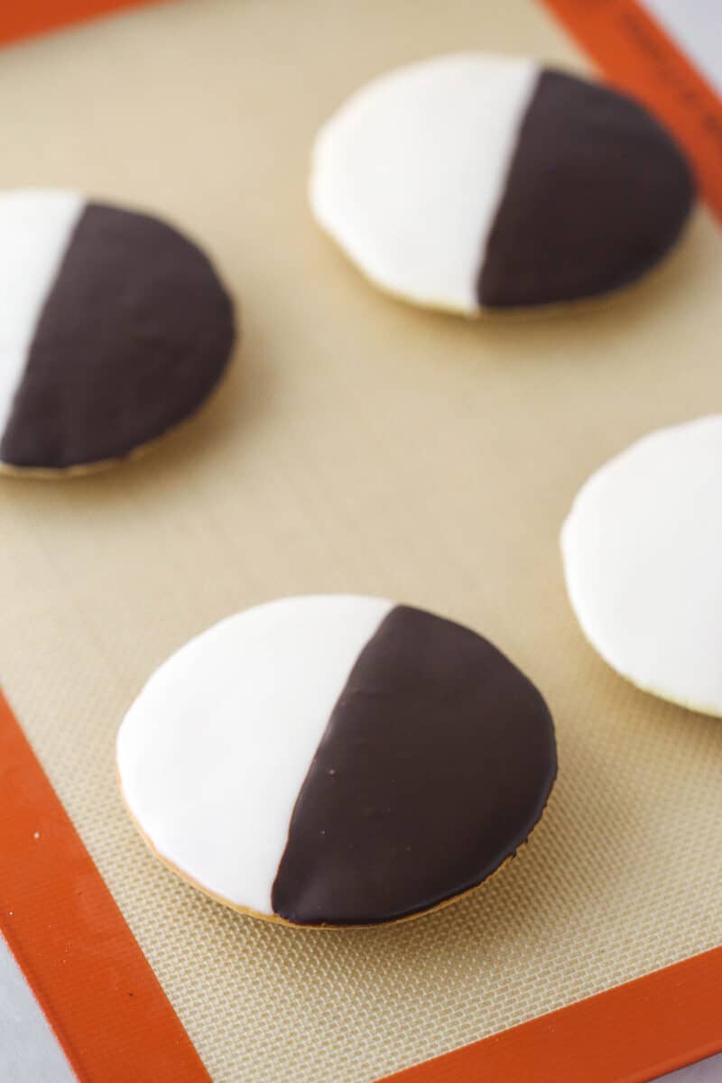 Half moon cookies on a silicon baking mat.